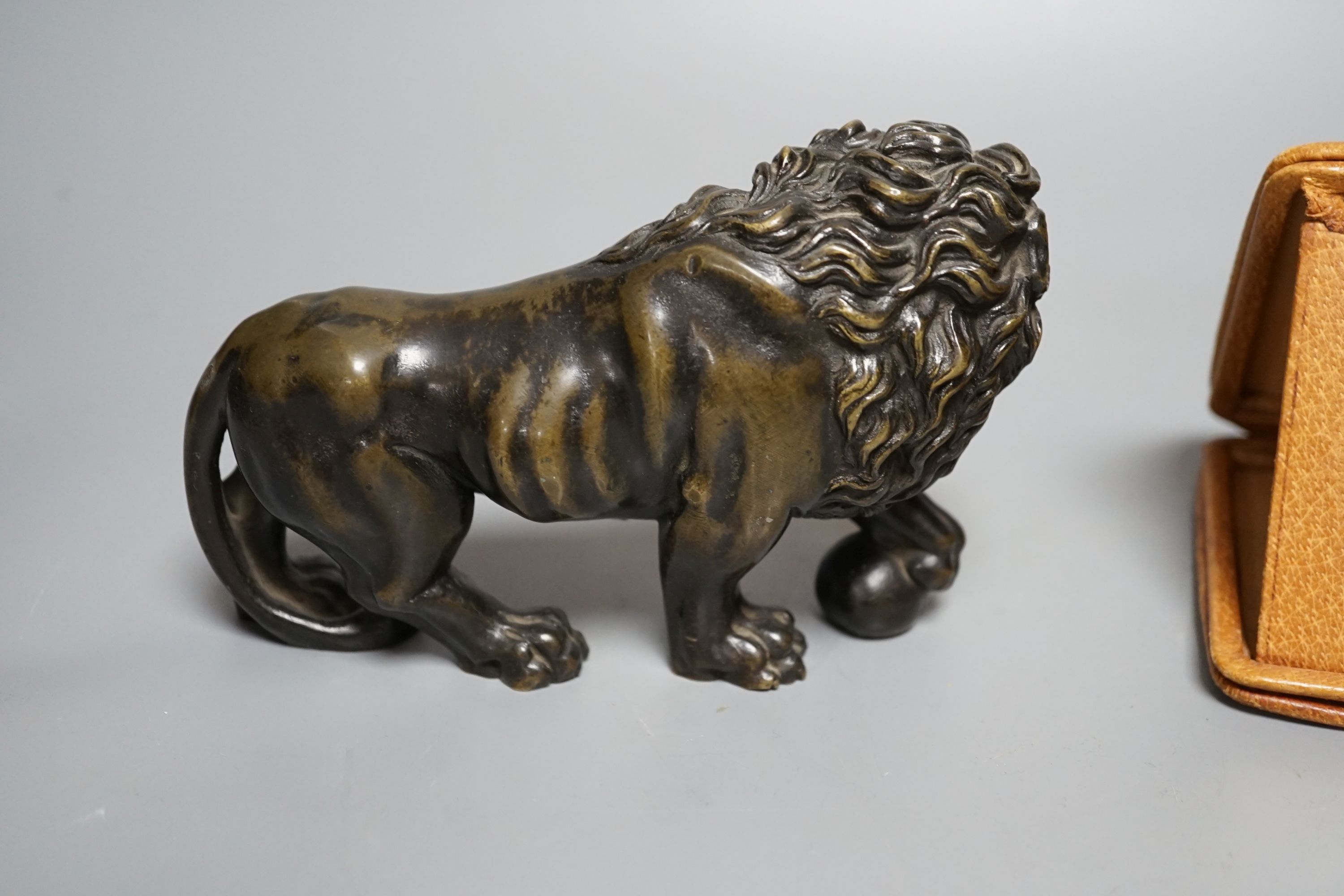 A bronze lion and Tiffany travelling watch, in tan leather case, lion 16.5 cms wide.